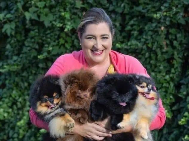 Ann Coughlin, holding 4 Pomeranian dogs